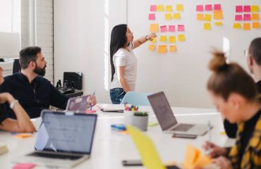 Women mentoring showing her notes to her colleagues