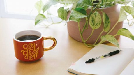 Notepad-and-Coffee with a plant on a table