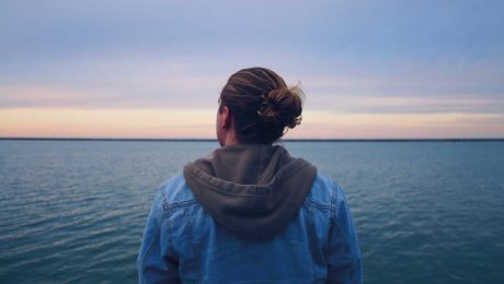 Man looking into the sky thinking while over the sea