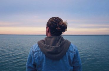 Man looking into the sky thinking while over the sea