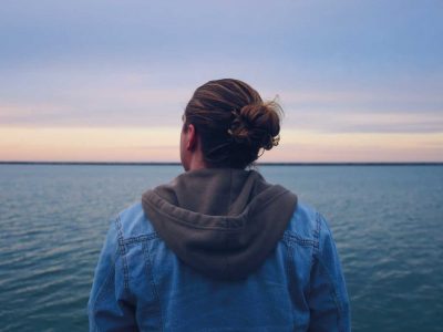 Man looking into the sky thinking while over the sea