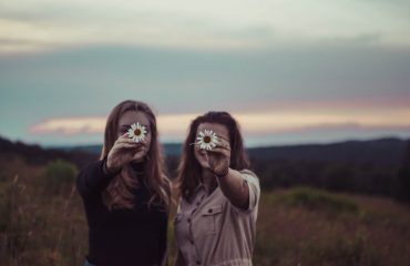 Two ladies in a field holding flowers