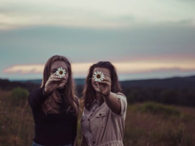 Two ladies in a field holding flowers