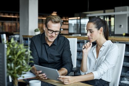 Two colleagues talking while scrolling through their ipad