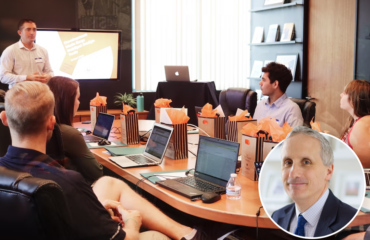 Meeting held round a table with laptops and goody bags