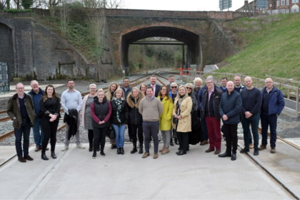 Group of Patrons pictured on a railway track smiling