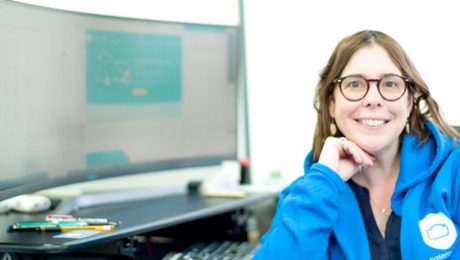 Lady in front of her laptop, at her desk in her workplace