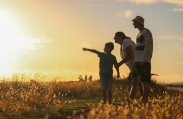 Family overlooking a field during a sunset