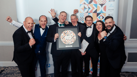 Wiltshee's Team holding their Awards at Staffordshire Chambers' Business Awards standing in front of the graphic wall