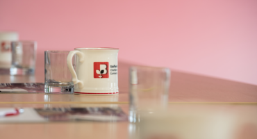 Staffordshire Chambers mug sat on a desk with other glasses for a meeting