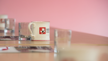 Staffordshire Chambers mug sat on a desk with other glasses for a meeting