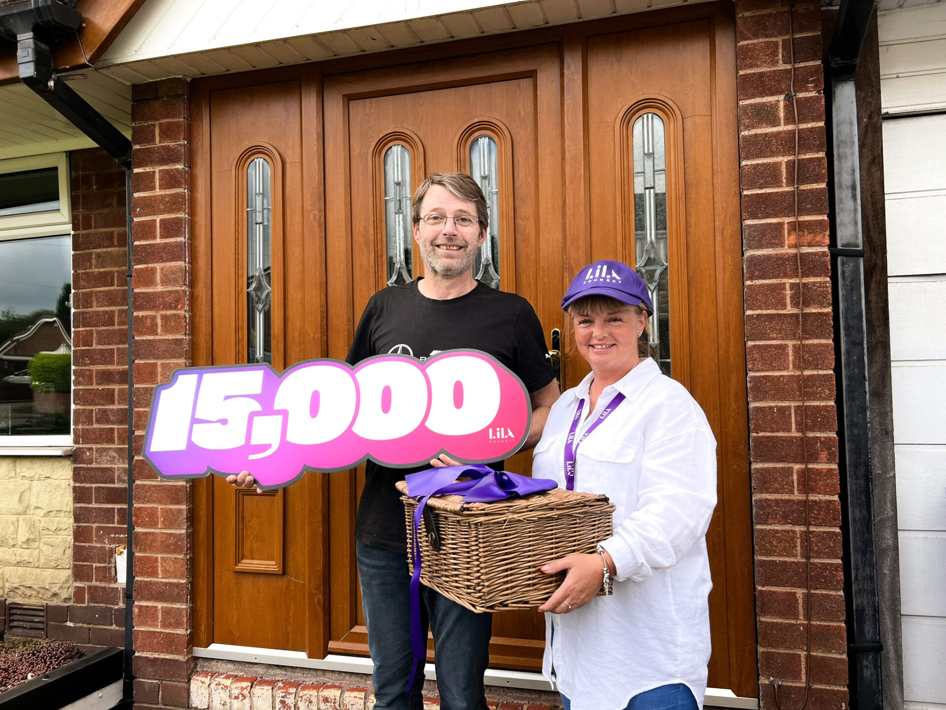 Picture of two people at a house with one holding a basket and refers tot he 15, 000 new customers of Lila broadband.