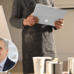 Picture of someone holding a laptop to paint, and a man is at the bottom left of the picture smiling.