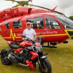 Picture of a person standing next to an air ambulance helicopter.