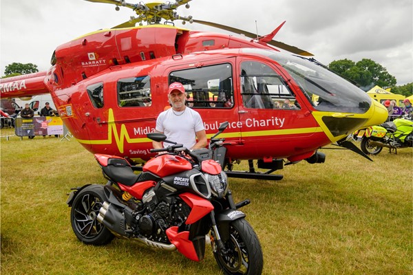 Picture of a person standing next to an air ambulance helicopter.