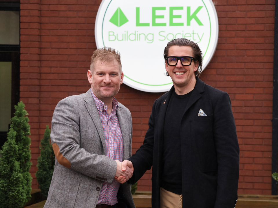 Andy Deeks and Chris plant shaking hands Infront of leek building society logo.
