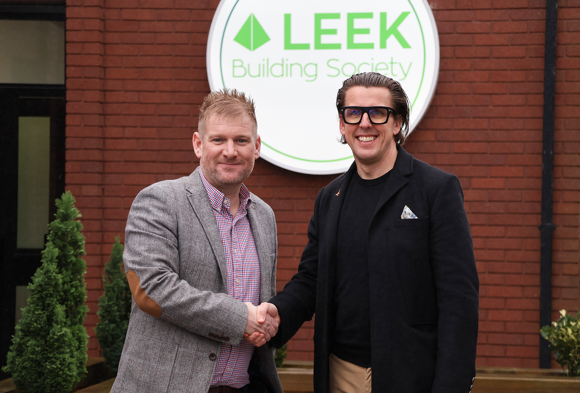 Andy Deeks and Chris plant shaking hands Infront of leek building society logo.