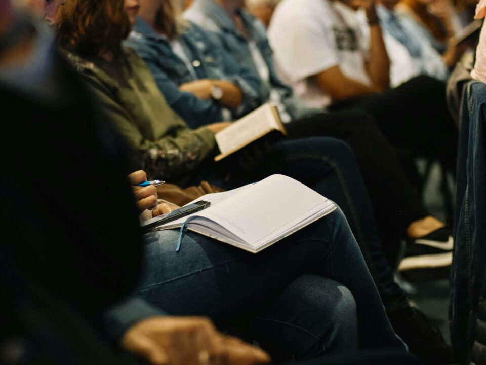 Picture of a group of people at an event taking notes.