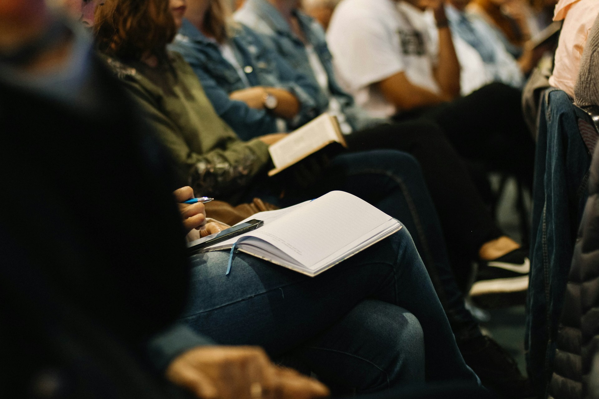 Picture of a group of people at an event taking notes.